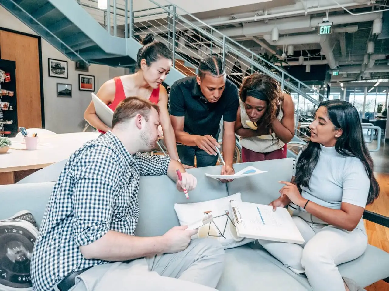 group-of-people-sitting-on-couch Group of employees discussing their team performance