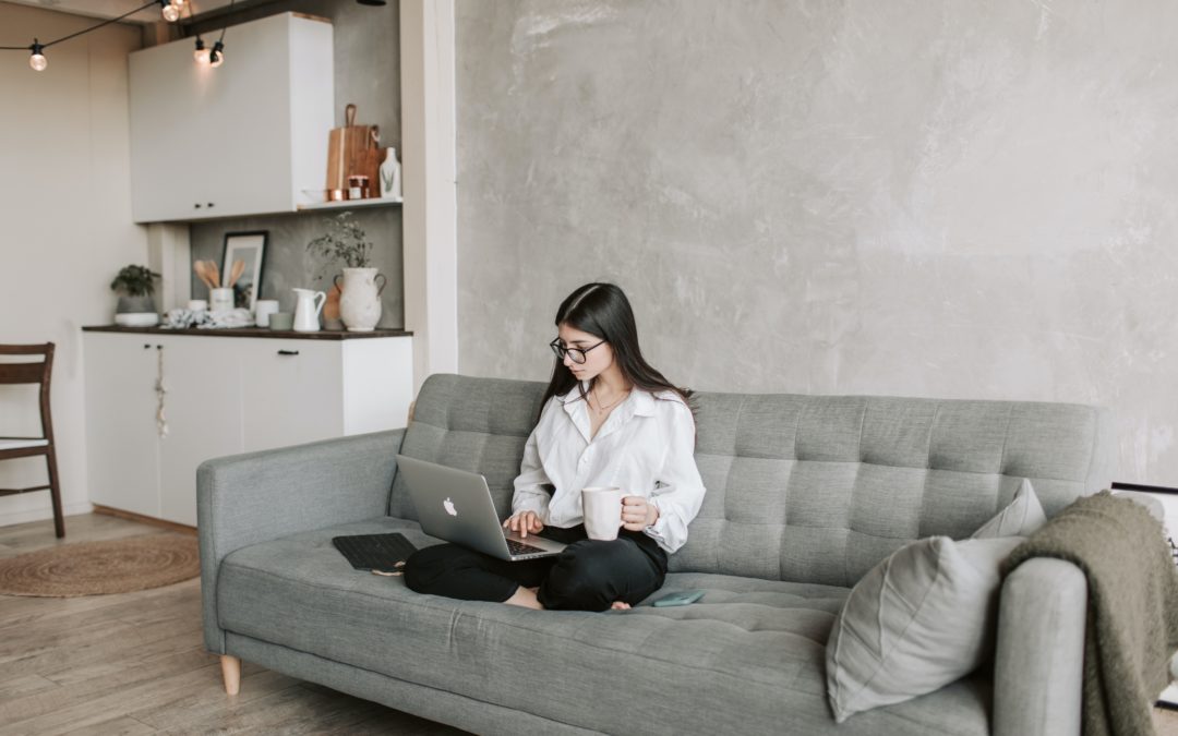 Woman doing virtual onboarding while sitting on couch