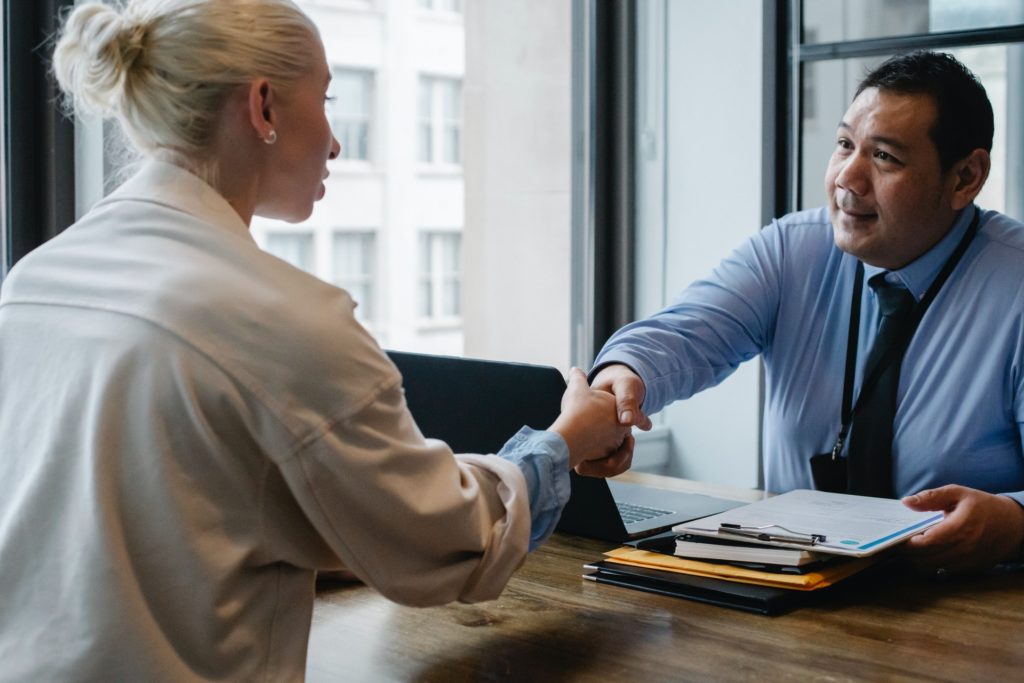 Employer and employee shaking hands after 90-day performance review