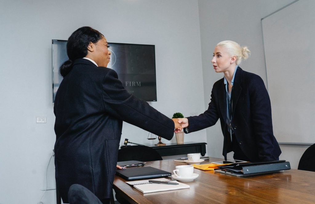 Manager and employee shaking hands after year end review