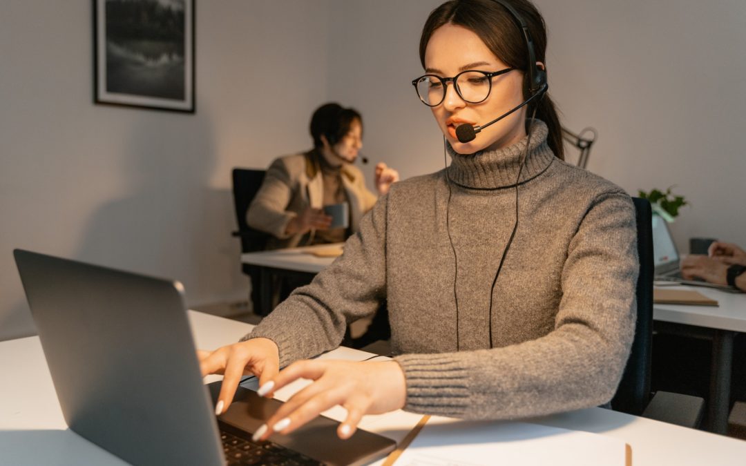 Woman using laptop wearing headset discussing employee engagement ideas