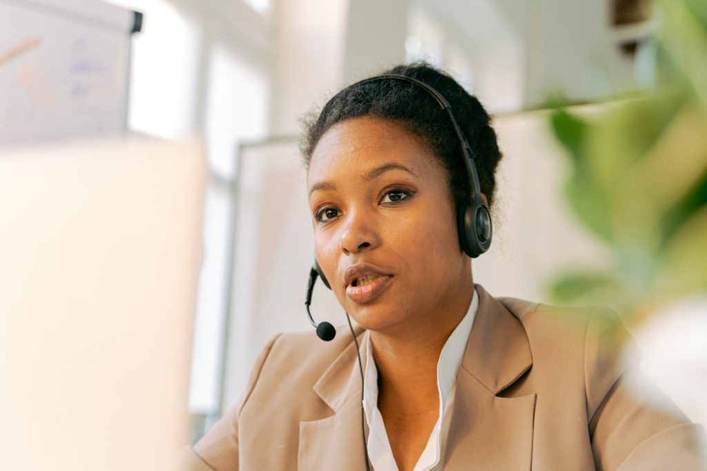 Corporate woman using headset at desk discussing employee experience