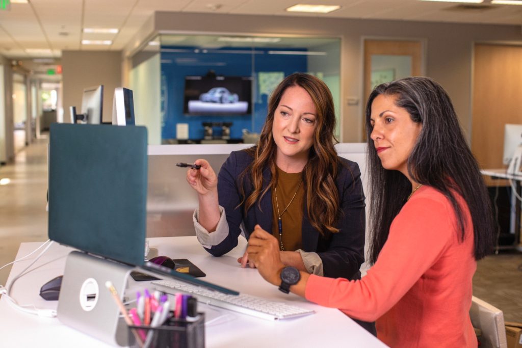 Professional woman showing 360 feedback questions to female colleague