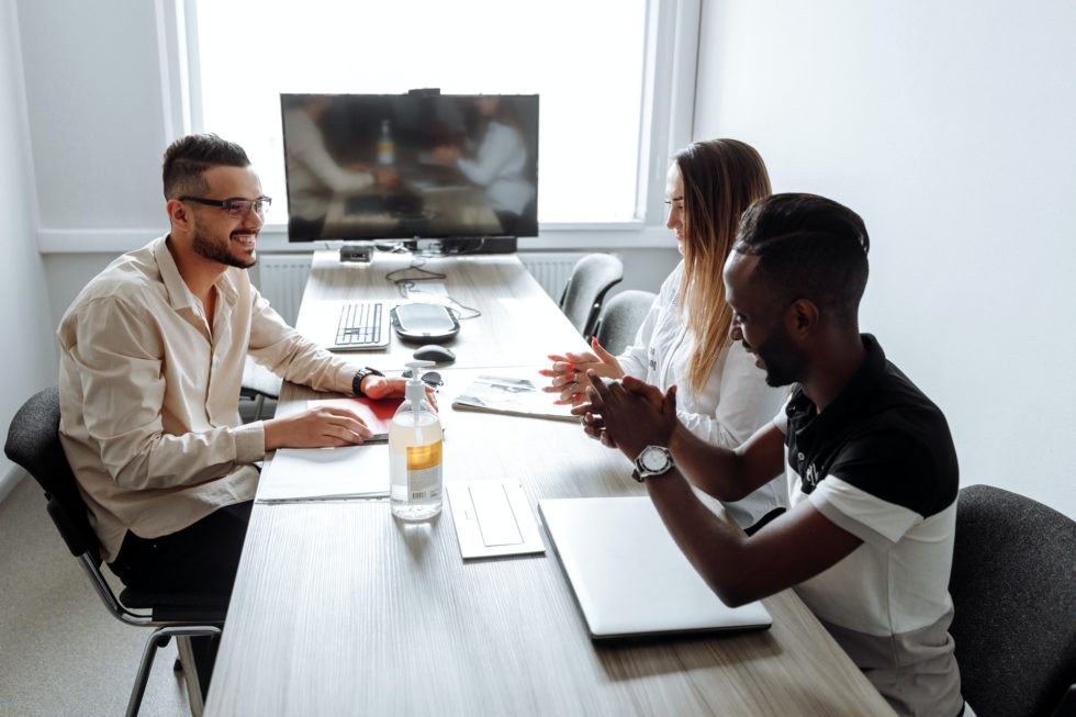 Three colleagues discuss an employee motivation survey in an office