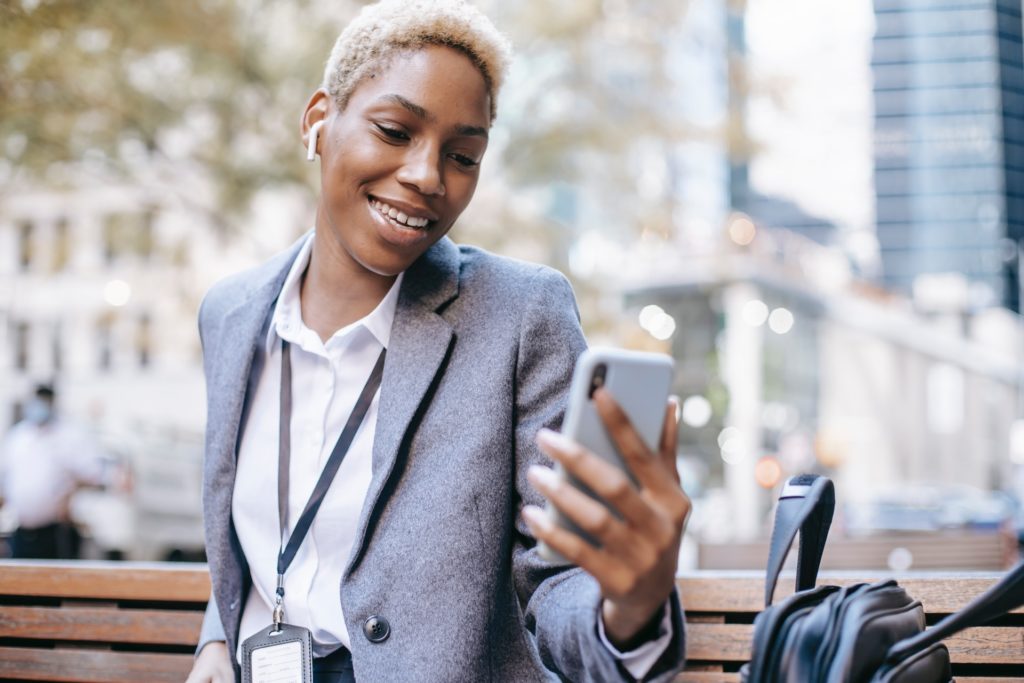 Black professional woman smiling at mobile phone