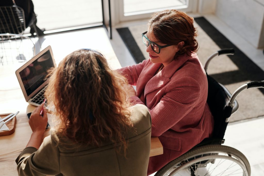 Woman in wheelchair and colleague going over career development plan