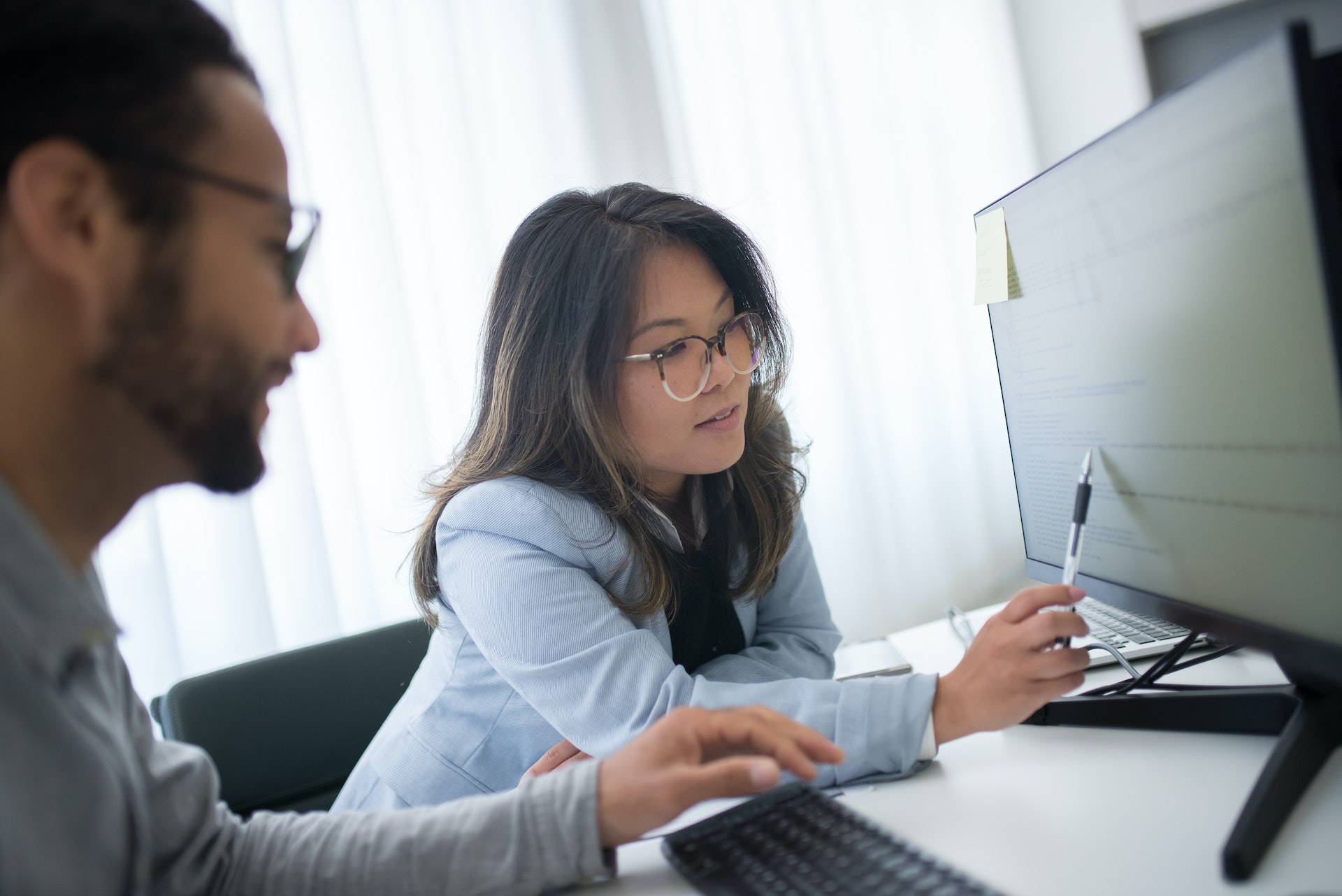 Asian woman reviewing performance management cycle with colleague