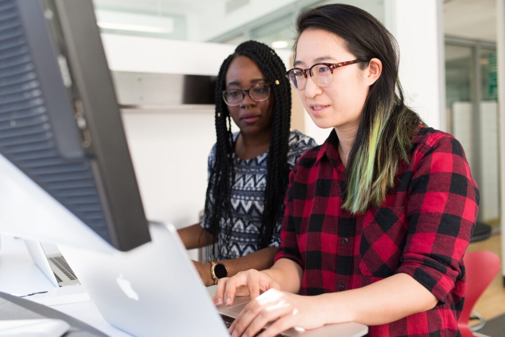 An Asian woman and a Black woman look at human skills information