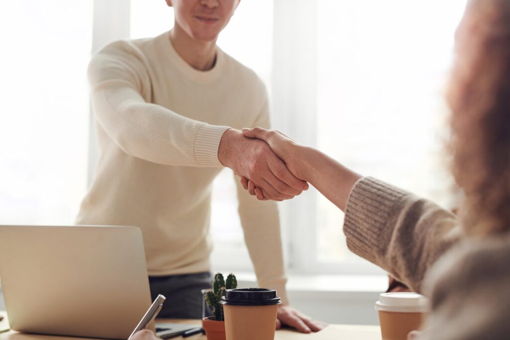 Employee shaking manager's hand after mid-year review