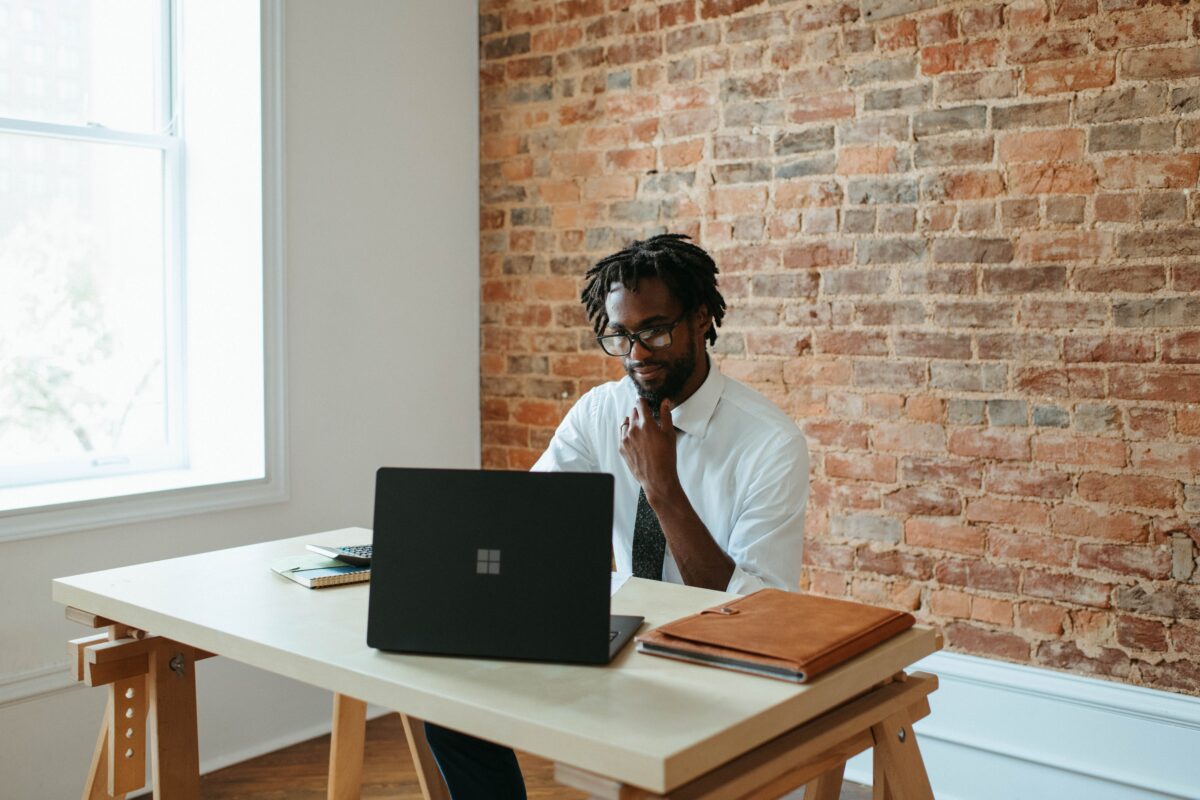 Black man using laptop to learn about manager effectiveness
