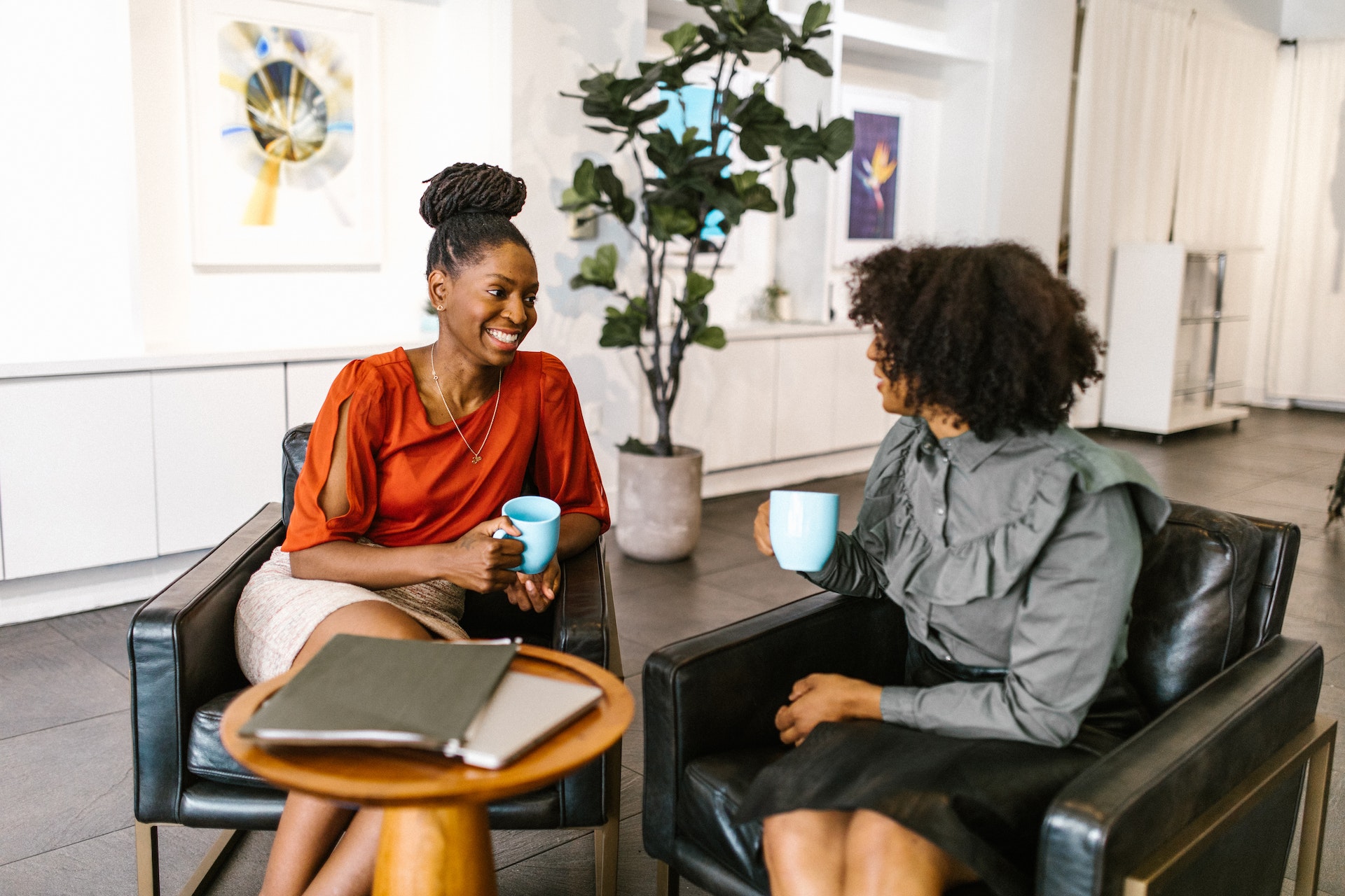 Two Black professional women discussing a leadership assessment