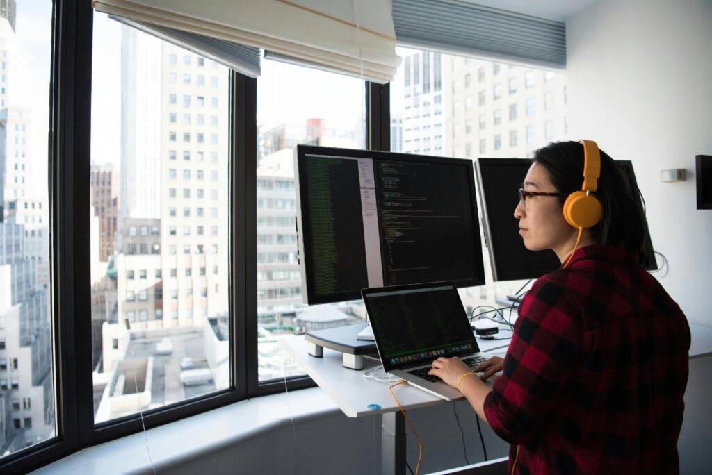 A woman looking at the window while working on her computer in her office