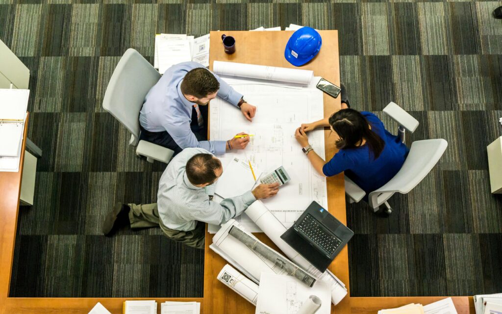 3 colleagues discussing employee performance around table