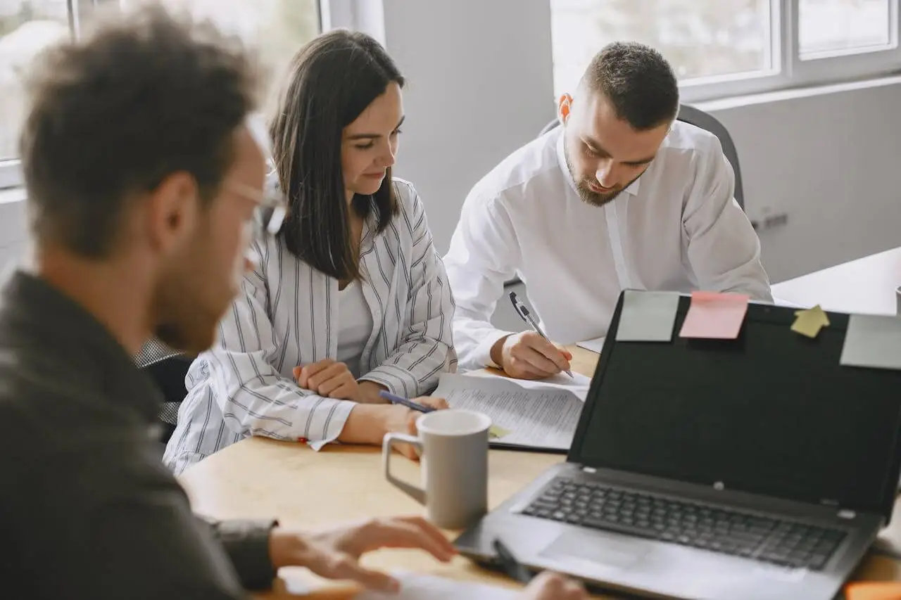 3-Employees-Working-Together-in-Office-with-Laptop