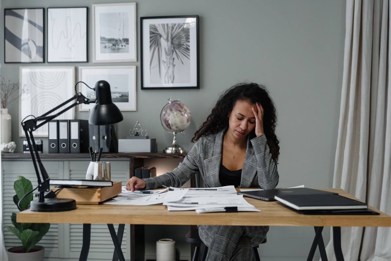 businesswoman-in-gray-suit-stressed-at-her-office-desk